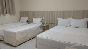 A bed or beds in a room at Glória Hotel