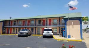 a hotel with two cars parked in a parking lot at Budget Inn - Washington in Washington