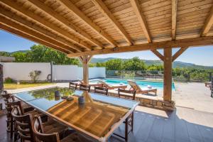 um pátio exterior com uma mesa e cadeiras e uma piscina em Villa Krasica em Krasica