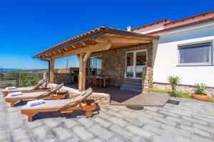 un patio con tumbonas y pérgola en Villa Krasica, en Krasica