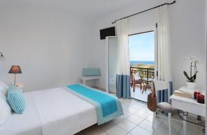 a bedroom with a bed and a view of the ocean at Iris Beach Hotel in Monemvasia