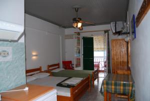 Habitación con 2 camas, mesa y sillas en Dimitris Apartments, en Vasiliki
