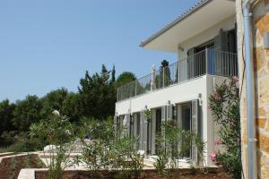a white house with a balcony at Myrtos View Apartments in Anomeriá