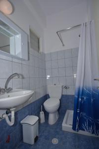 ein Bad mit einem WC, einem Waschbecken und einer Dusche in der Unterkunft Nikos Rooms in Votsi