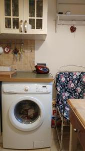 a washing machine in a kitchen with a chair at W kamienicy in Gdańsk