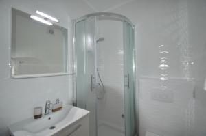 a white bathroom with a shower and a sink at Apartments Silvia in Zadar +55 photos