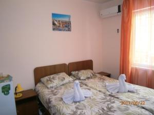 a bedroom with a bed with two swans on it at Guest house Barhatniy sezon in Novy Afon