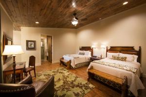 a bedroom with two beds and a desk and a couch at Joshua Creek Ranch in Boerne