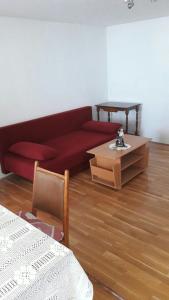 a living room with a red couch and a table at Apartman BARAKA in Šibenik
