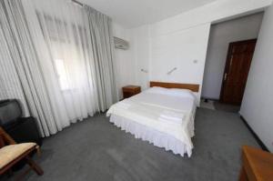 a bedroom with a white bed and a large window at Mer Pansiyon in Fethiye +7 photos