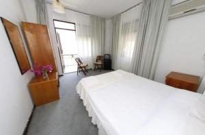 a bedroom with a white bed and a window at Mer Pansiyon in Fethiye