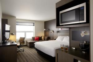 a hotel room with a bed and a flat screen tv at Hyatt House Raleigh/Rdu/Brier Creek in Raleigh +42 photos