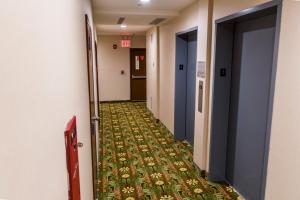 a hallway that has a rug and a door in it at John Hotel in Queens