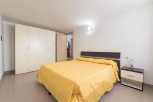 a bedroom with a yellow bed and white cabinets at Residence Blue Pearl in Marina di Camerota