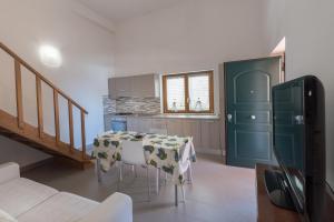 a kitchen with a table and a green door at Residence Blue Pearl in Marina di Camerota