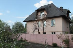 a house with a black roof and a pink fence at Hostel Teremok in Kyiv