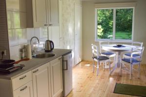 uma cozinha com um lavatório e uma mesa com cadeiras em Nurmeveski Holiday House em Nurme