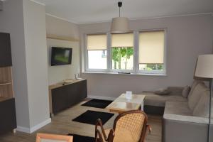 a living room with a couch and a table at Apartamenty Willa Nawigator in Gdynia