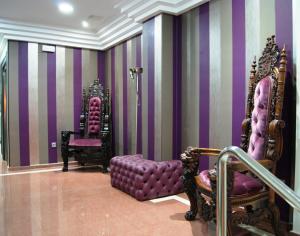 Habitación con paredes y sillas de rayas púrpura y púrpura en Hotel Doña Luisa, en San Luis de Sabinillas