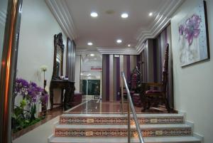 a lobby with stairs and flowers on the wall at Hotel Doña Luisa in San Luis de Sabinillas