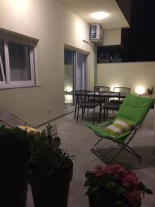 un patio con una silla verde y una mesa en Z&D Apartment, en Pula