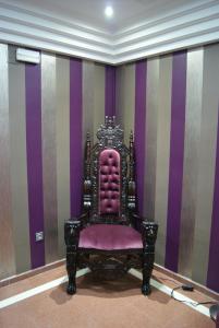a chair in a room with purple and purple stripes at Hotel Doña Luisa in San Luis de Sabinillas