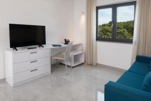 Televízia a/alebo spoločenská miestnosť v ubytovaní Aparthotel Punta Blu - POOL & SPA