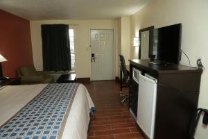 a hotel room with a bed and a flat screen tv at Budget Inn - Washington in Washington