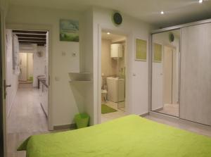 a bedroom with a green bed and a bathroom at Apartments 4M in Kostrena