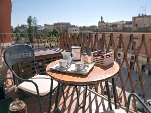 a table with two chairs and coffee cups on a balcony at Le Caruse in Lecce