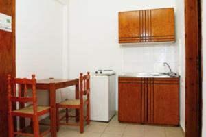 a kitchen with a sink and a table and a refrigerator at Kato Stalos Beach in Stalos