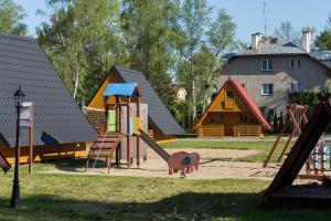 ポビエロボにあるDomki Diamentの遊び場(スライダー付)と家屋のある公園