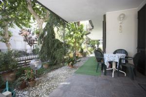 a patio with a table and chairs and plants at Albergo Villa Denny in Rimini