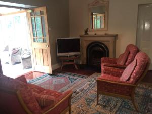 a living room with two chairs and a television at Creevy Lodge in Castlederg