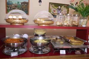 a buffet of food on a shelf with bowls of food at Taperapuan Praia Hotel in Porto Seguro