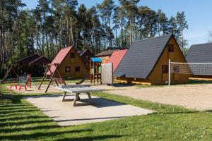 a park with a bench and a playground at Domki Diament in Pobierowo