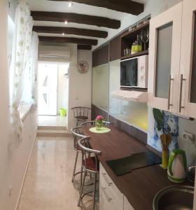 una cucina con armadi bianchi e un bancone con sgabelli di Apartments 4M a Kostrena (Costrena)