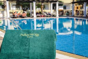 - une serviette assise à côté de la piscine dans l'établissement Pefkos Village Resort, à Pefki