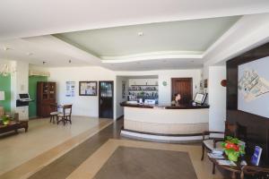 a lobby of a pharmacy with a woman sitting at a counter at Pefkos Village Resort in Pefki Rhodes +61 photos
