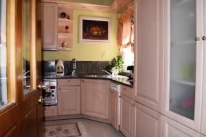 a kitchen with white cabinets and a sink at Palio Villa in Paleo Tsifliki