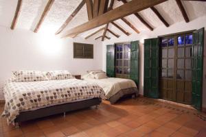 a bedroom with two beds and green glass doors at Cabaña NIDO VERDE in Iza