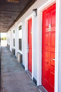 dos puertas rojas en el lateral de un edificio en Lockhart Inn, en Lockhart