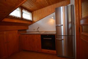 a kitchen with a stainless steel refrigerator in a cabin at Attico Castello in Cortina dʼAmpezzo