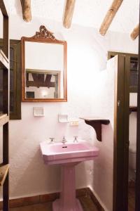 ein Badezimmer mit einem rosa Waschbecken und einem Spiegel in der Unterkunft Cabaña NIDO VERDE in Iza