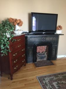 sala de estar con chimenea y TV en la parte superior en Le Gîte De La Sagouine, en Bouctouche