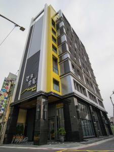 um edifício com um edifício amarelo e preto em Watermark Hotel Kaohsiung Main Station em Kaohsiung