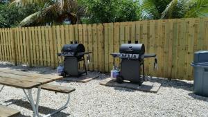 a backyard with a grill and a wooden fence at Knight's Key Suites in Marathon