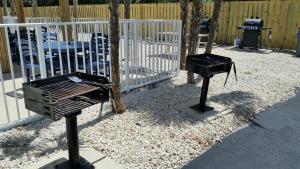 a grill and smoker in front of a fence at Knight's Key Suites in Marathon