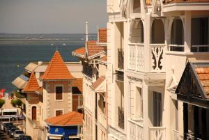 a group of buildings on a street next to the water at Residhome Arcachon Plazza in Arcachon