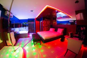 Zimmer mit einem Bett, Stühlen und Beleuchtung in der Unterkunft Platinum Motel (Adults Only) in Fortaleza